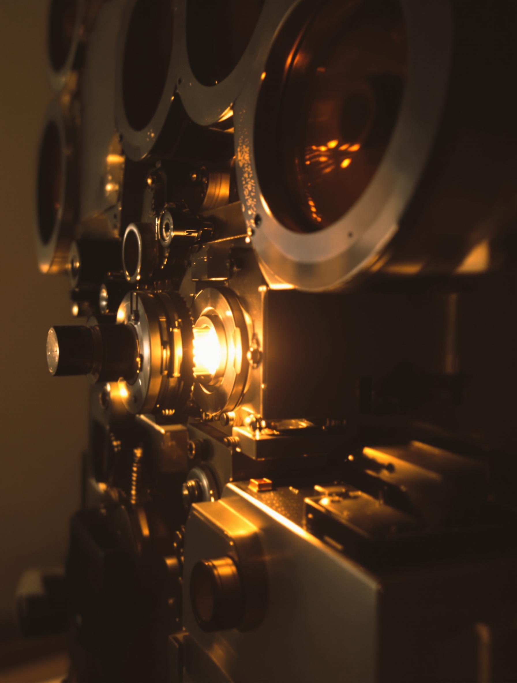 Vue rapprochée d’un projecteur Super 8 authentique, ses rouages apparents et sa lueur nostalgique.