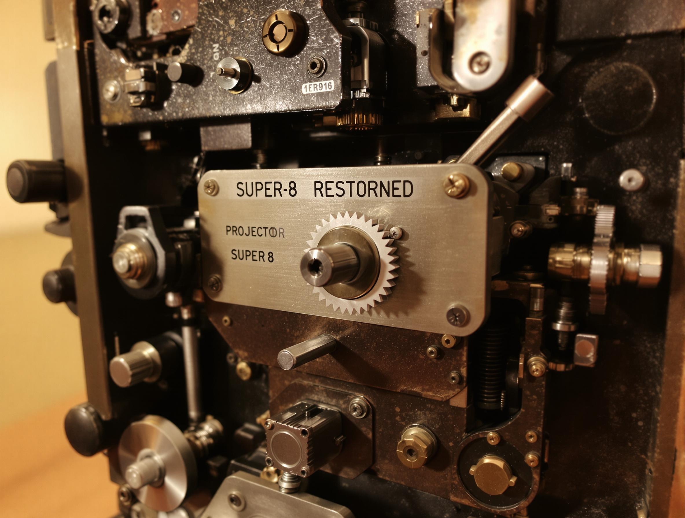 Photo d'un projecteur Super 8 restauré avec soin montrant ses pièces authentiques.