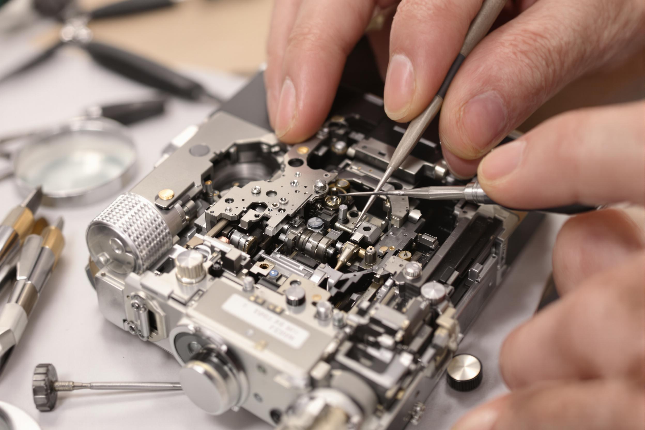 Technicien réparant un déclencheur de caméra vintage